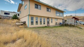 A two-story house with a flat roof, large windows, and a visible garage. - Yellowstone Country Retreat: Stunning Views! (Livingston)