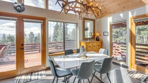 A dining area with a large table, chairs, and a chandelier made of antlers. - Angel Fire Retreat w/ Hot Tub ~ 5 Mi to Skiing (Angel Fire)