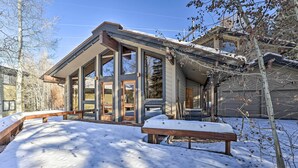 Une maison moderne dotée de grandes fenêtres et d’un porche abrité.