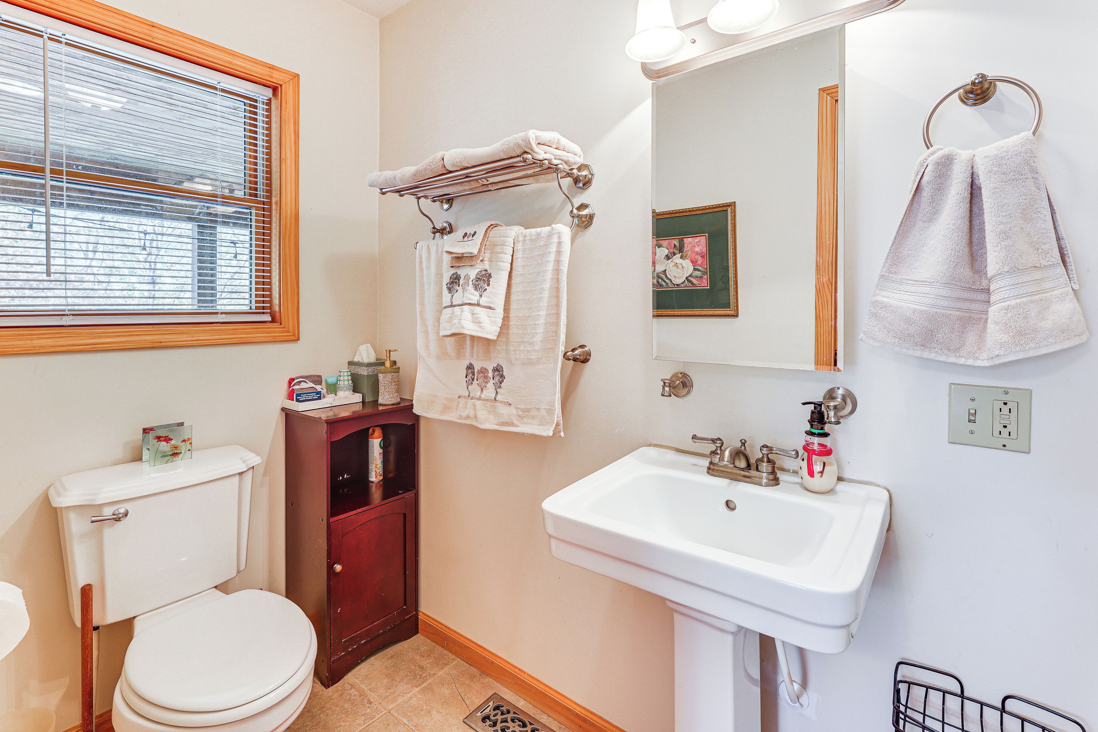 Een badkamer met toilet, wastafel en handdoekhouder.