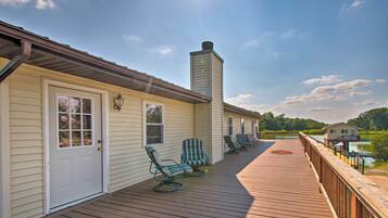 A wooden deck with outdoor seating and a view of a lake.
