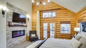 A log cabin interior with a fireplace, a flat-screen TV, a bed, and a large window. - Spacious Mtn Manor, 1 Mi to Brian Head Resort! (Brian Head)