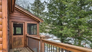 A wooden cabin with a balcony, large windows, and a view of trees and snow. - Spacious Cabin: 10 Mi to Sunday River Skiing! (Bethel)