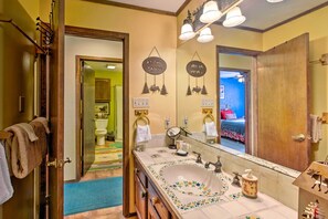 A bathroom with a large mirror, a sink with floral tiles, and a towel rack. - Serene Angel Fire Cabin w/ Community Pools! (Angel Fire)