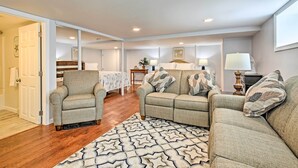 A living room with a sofa set, a chair, a patterned rug, and a dining area with a table and chairs. - Old Orchard Beach Home w/ Patio: Walk to Beach (Old Orchard Beach)