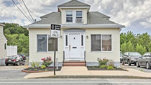 A single-story house with a white door and windows, a small front porch, and a sign indicating a right lane for bicycles only. - Old Orchard Beach Home w/ Patio: Walk to Beach (Old Orchard Beach)