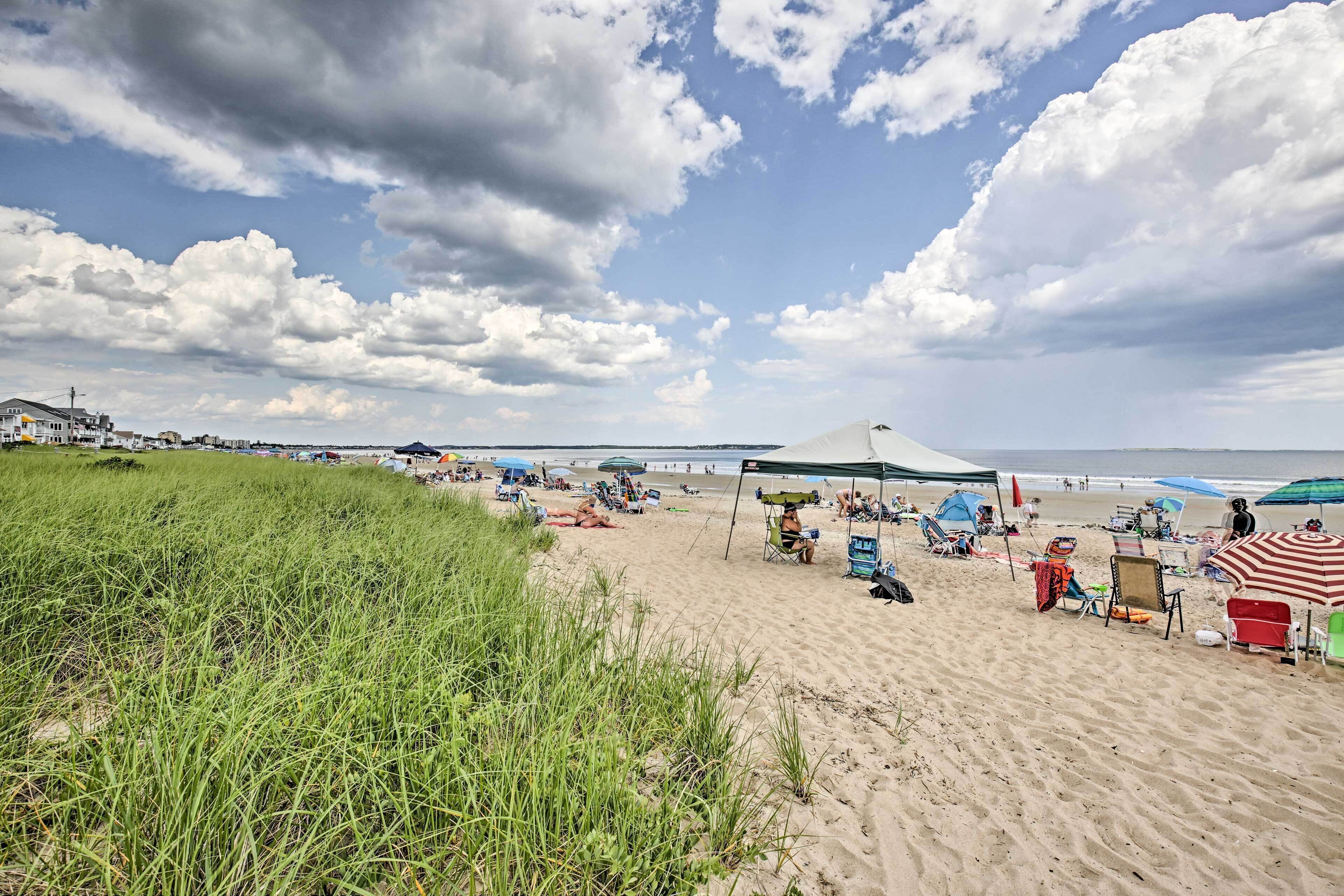 A beach with tents, chairs, and umbrellas.