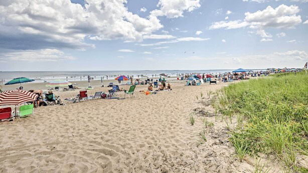 A sandy beach with umbrellas and beach chairs. - Old Orchard Beach Home w/ Patio: Walk to Beach (Old Orchard Beach)
