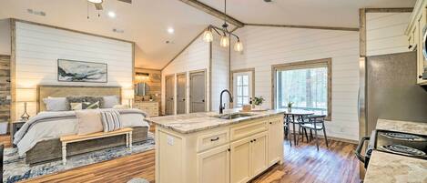 Una cocina amplia con una isla central, piso de madera y un ventilador de techo.