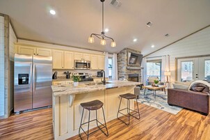 Una cocina moderna con una isla grande, electrodomésticos de acero inoxidable y una pared de acento de piedra.