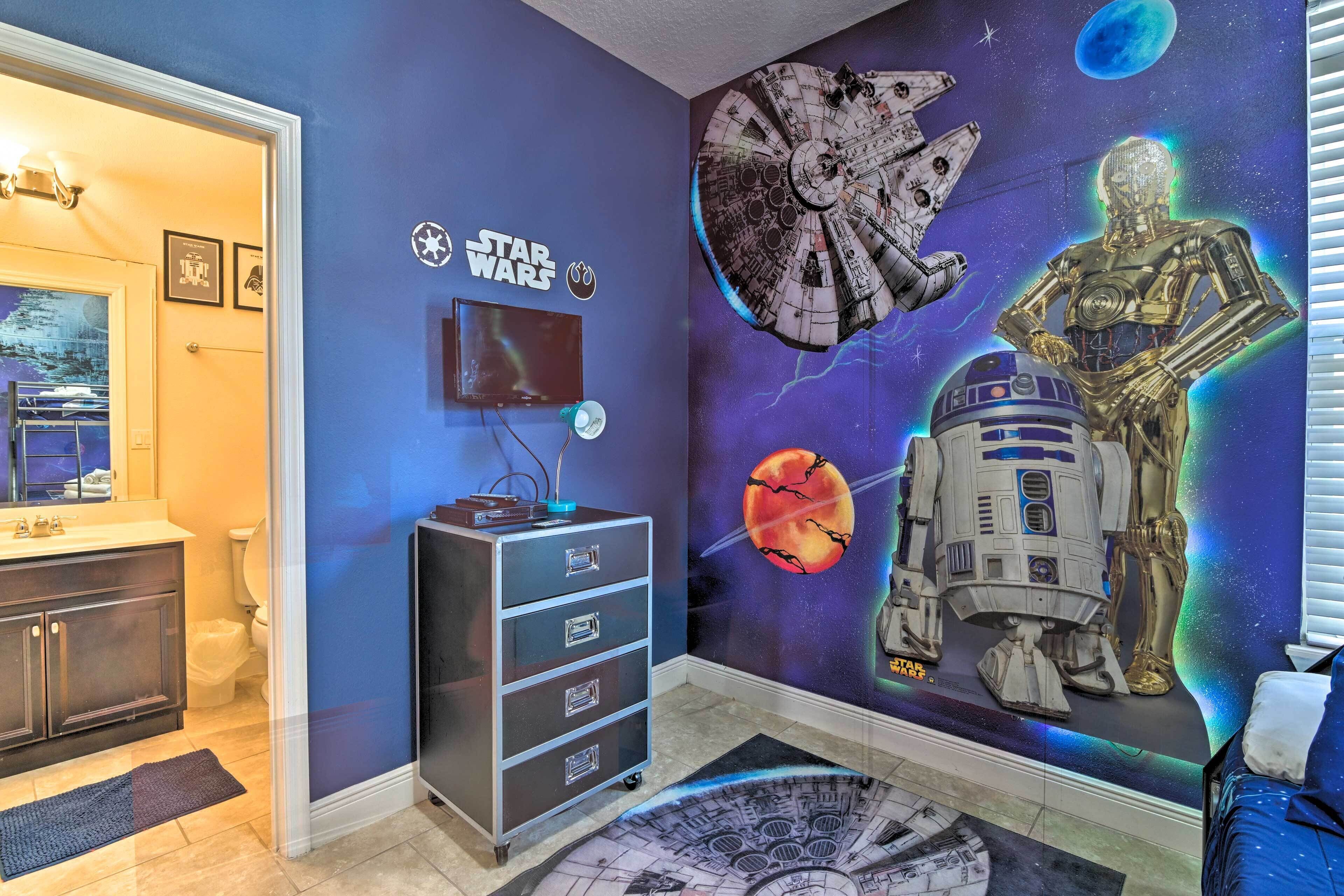Ein Badezimmer mit Wandgemälde zum Thema Star Wars, einem Schminktisch mit Spiegel und einem Waschbecken.