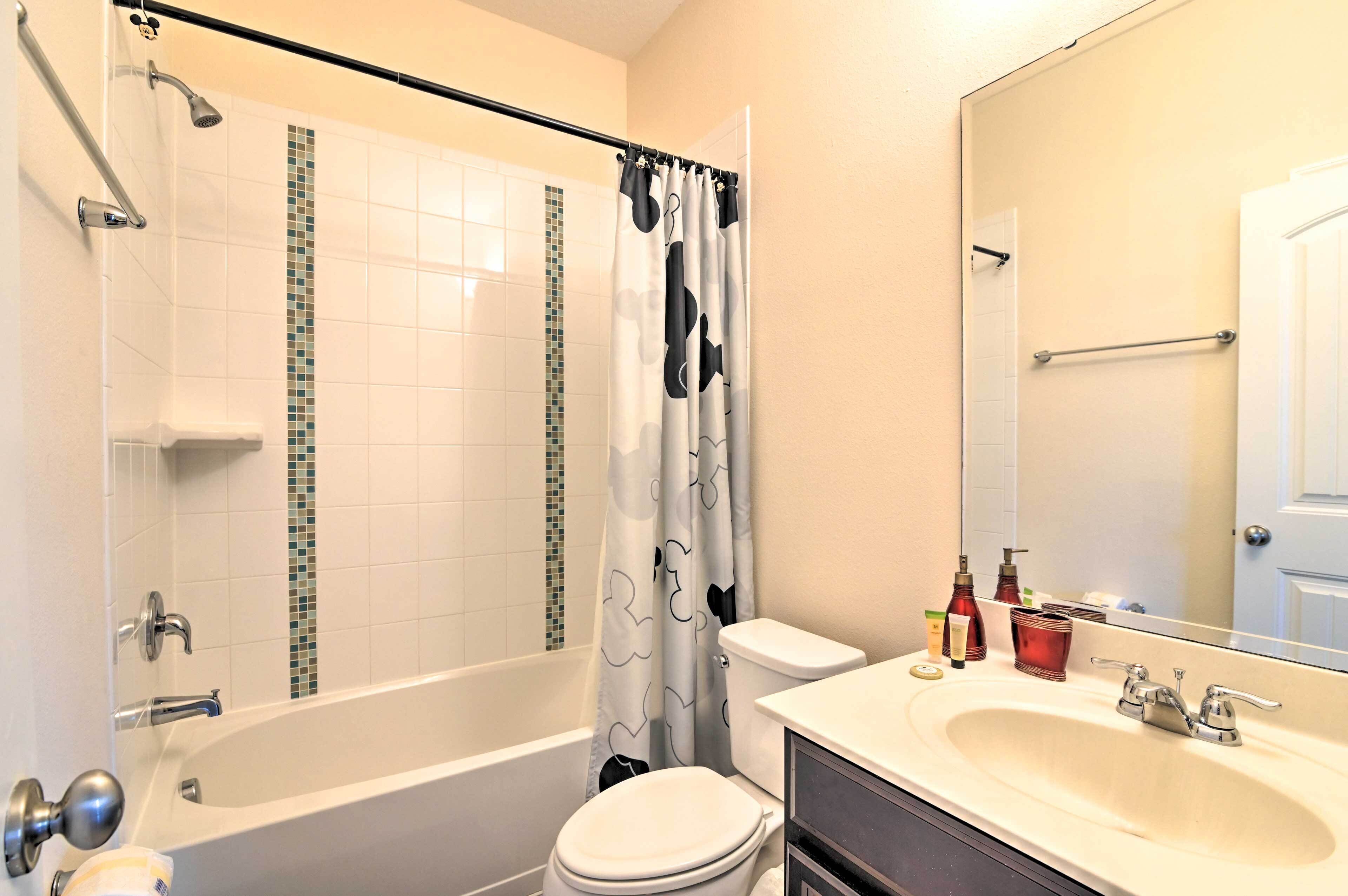 A bathroom with a bathtub, toilet, and sink.