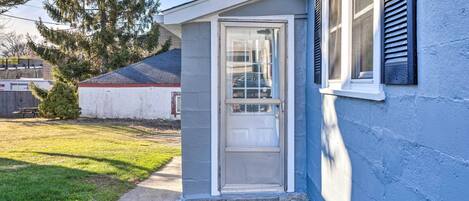 A house with a small front porch, a sliding glass door, and a blue exterior wall.