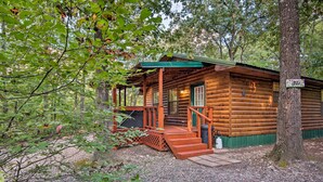 A rustic log cabin with a porch, surrounded by trees. - Broken Bow Cabin w/ Hot Tub, Near Hiking + Fishing (Broken Bow)