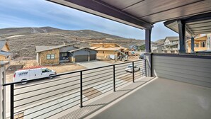 A balcony with a view of a residential area, including houses and a construction site. - Inviting Hideout Townhome w/ Balcony & Lake Views! (Heber City)