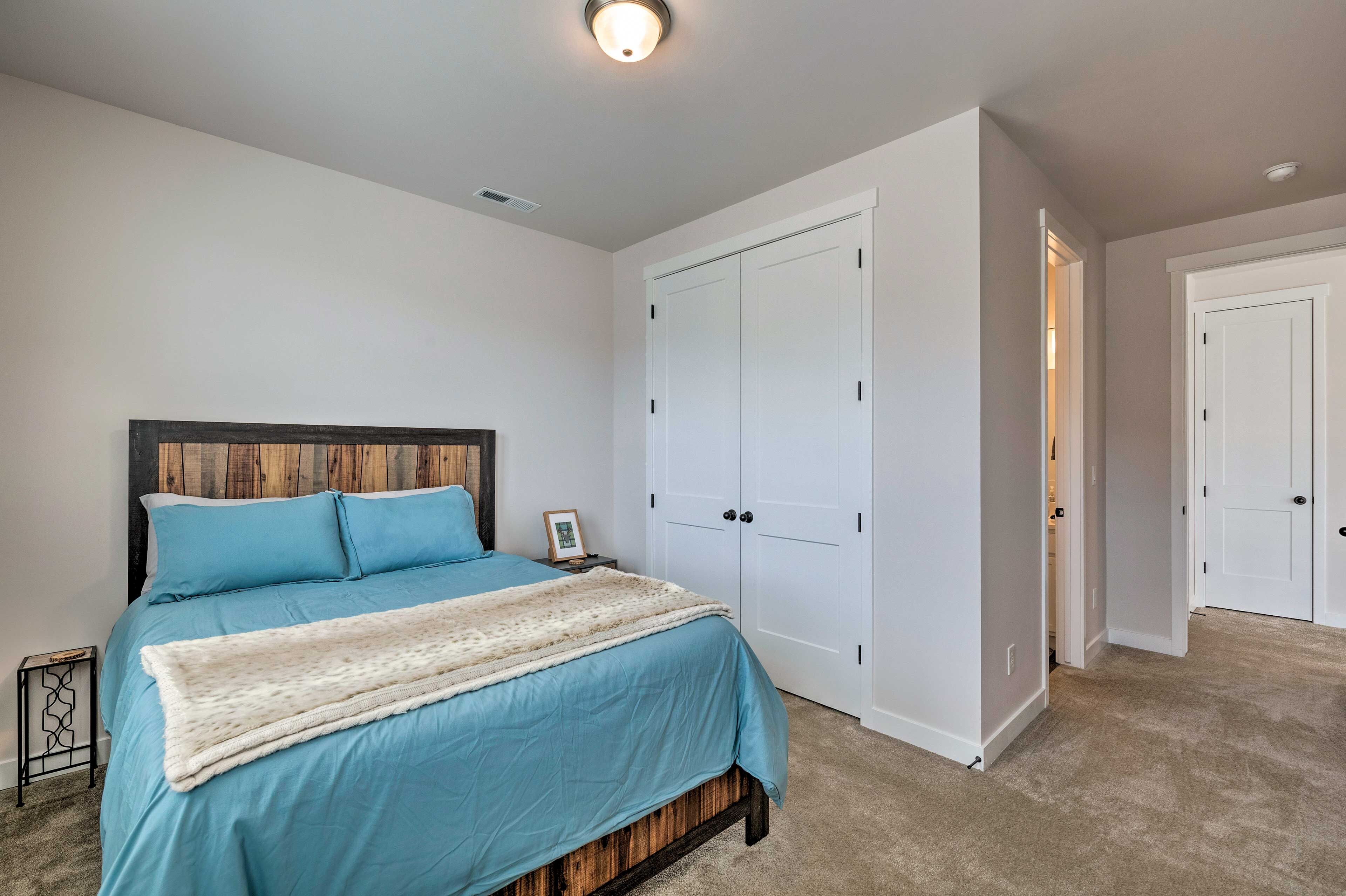 A bedroom with a bed, a nightstand, a wardrobe, and a door.