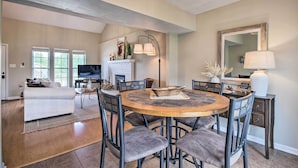 A spacious living room with a round wooden dining table surrounded by chairs, a fireplace, and a television. - Relaxing Townhome, 4 Mi to Mizzou University! (Columbia)