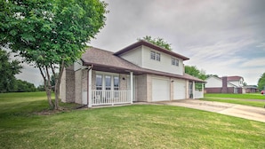 A two-story house with a garage, a covered porch, and a well-maintained lawn. - Relaxing Townhome, 4 Mi to Mizzou University! (Columbia)