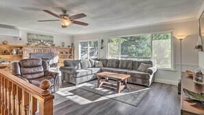 A spacious living room with a sectional sofa, a leather recliner, and a wooden coffee table. - Furnished Deck & Nat'l Forest Views: Arnold Cabin (Arnold)