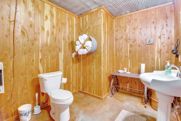 A wooden-paneled bathroom with a toilet, sink, and a towel rack. - Ozark Mtn Views: Secluded Everton Retreat (Everton)