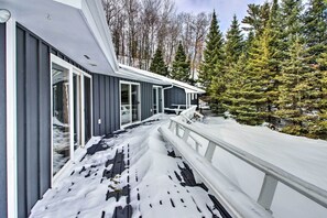 Situated in a wooded area, this two-story building offers a covered outdoor space with a deck for relaxation and outdoor activities.