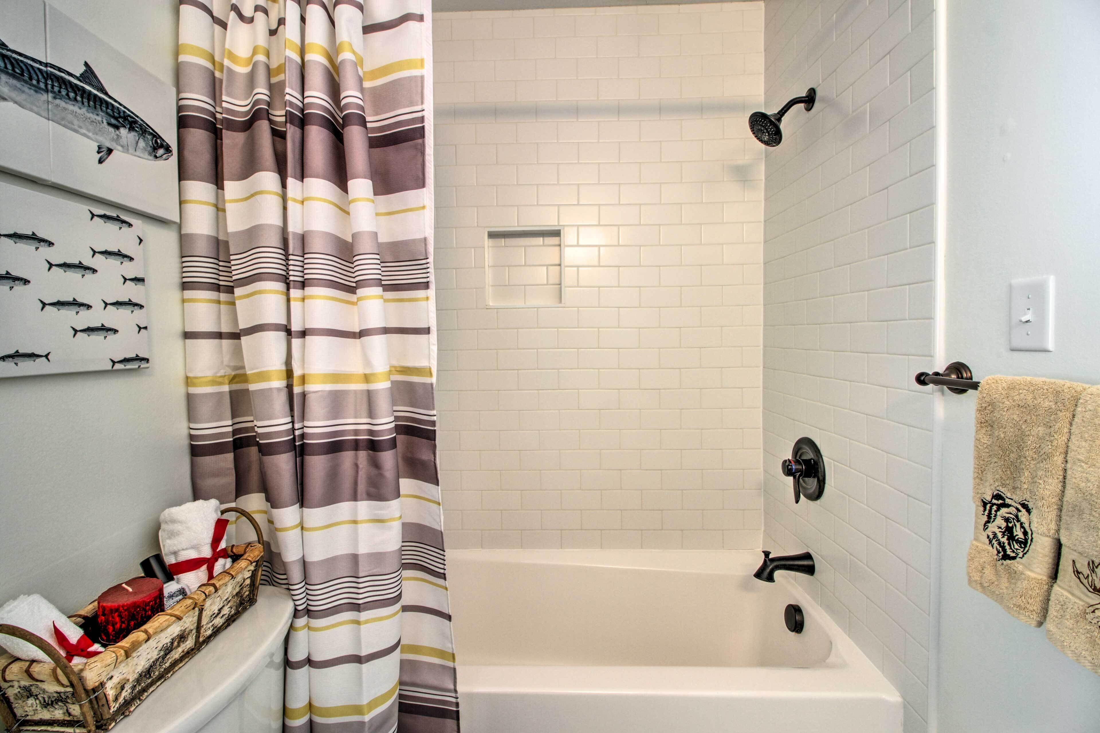 A bathroom with a bathtub, a shower, and a towel rack.