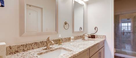 A bathroom with a double sink, a large mirror, and a glass shower enclosure.