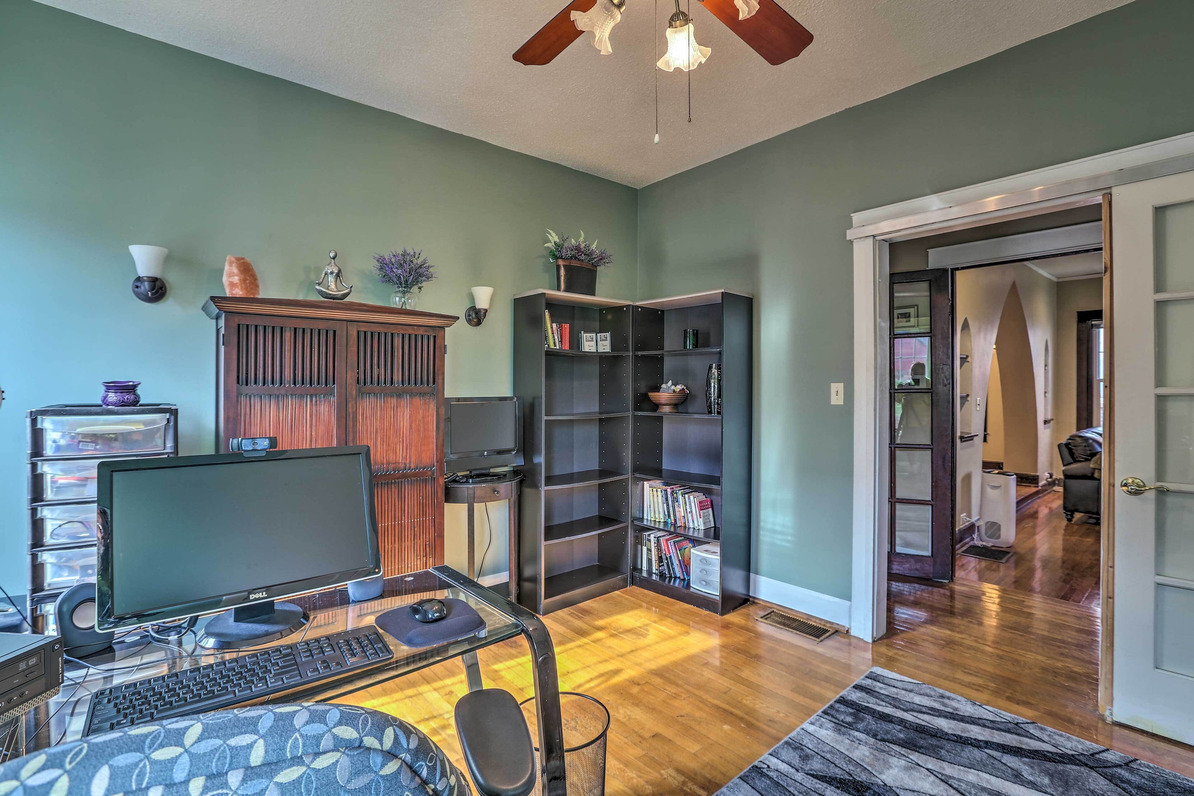 A home office with a desk, computer, and bookshelf.