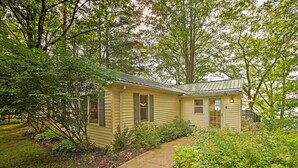 A single-story house with a sloped roof, surrounded by lush greenery and a well-maintained garden. - 2 Mi to Winery: Le Roy Escape w/ Fire Pit & Views (Le Roy)