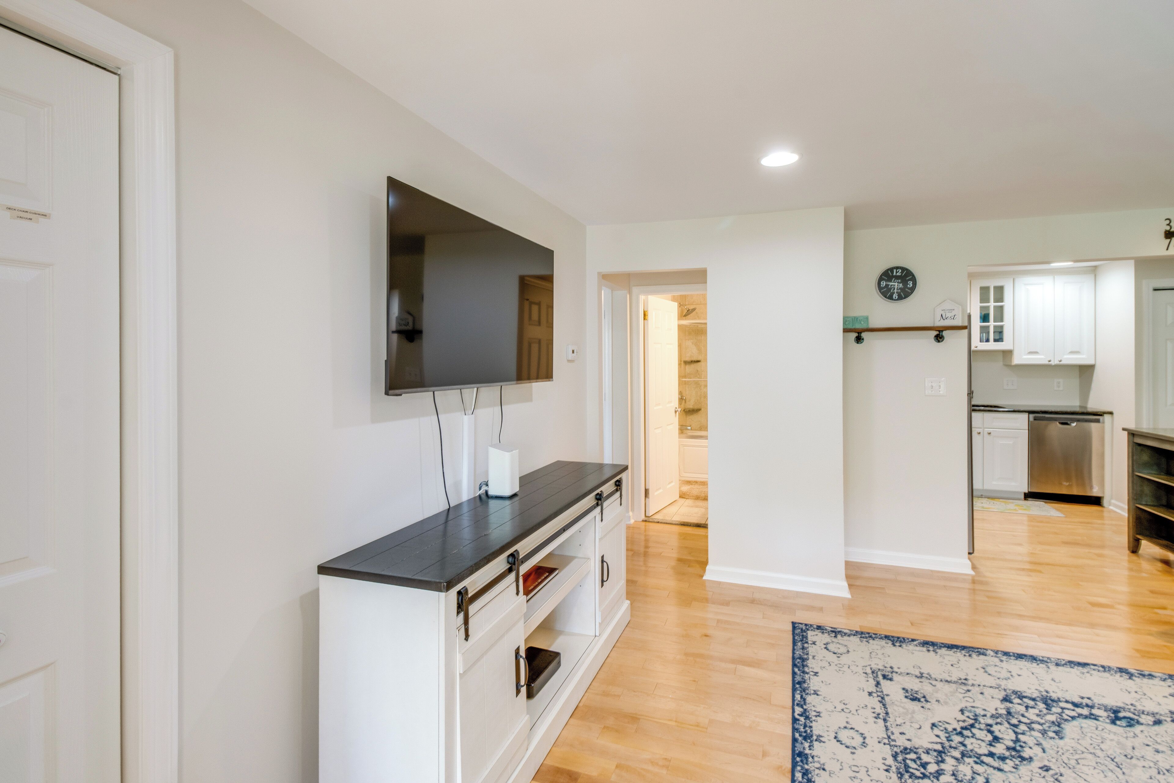 A modern kitchen with white cabinets, a built-in oven, and a stainless steel dishwasher.