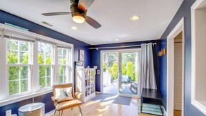 A spacious room with a large window, a ceiling fan, and a sliding glass door leading to an outdoor patio. - Cape May Quad w/ Grill - 7 Blocks to Beach! (Cape May)