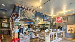 A cafe with a wooden counter, menu boards, and a 'No Smoking' sign.