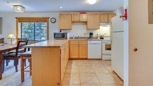 A modern kitchen with wooden cabinets, a microwave, a dishwasher, and a refrigerator.