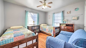 A bedroom with two wooden beds, a blue sofa, a ceiling fan, and a wooden dresser. - Outdoor Dining & Yard: Pet-friendly Temple Home (Temple)