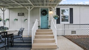 A porch with a turquoise door, a welcome sign, and a staircase leading to the entrance. - Boat & Fish on Lewisville Lake: Pet-friendly Haven (Lake Dallas)