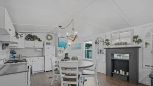 A kitchen with white cabinets, a round dining table, and a chandelier. - Boat & Fish on Lewisville Lake: Pet-friendly Haven (Lake Dallas)