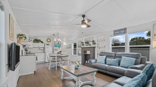 A spacious living area with a grey leather sofa, a wooden coffee table, and a kitchen in the background. - Boat & Fish on Lewisville Lake: Pet-friendly Haven (Lake Dallas)