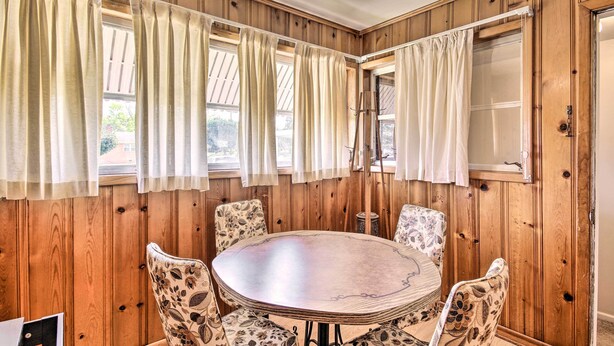 A wooden-paneled room with a round table and floral-patterned chairs. - Charming Aiken Vacation Rental 2 Mi to Dtwn! (Aiken)