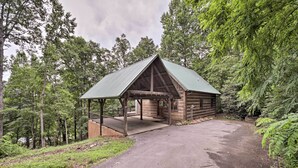 Eine rustikale Holzhütte mit Veranda, umgeben von dichtem Wald.