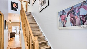 Portaat, joissa on puiset askelmat ja puinen kaide, johtavat ylempään kerrokseen.