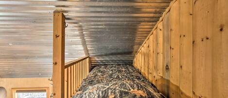 Ein Etagenbett mit wasserabweisender Matratze, Holzgeländern und Metallverkleidung an der Decke.