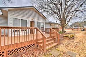 A two-story house with a wooden deck and a staircase leading to the front porch.
