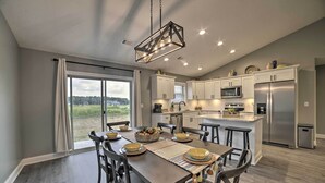 A modern kitchen with white cabinets, stainless steel appliances, and a large island. - Cozy Murray Retreat Near MSU & Local Eateries (Murray)
