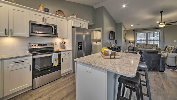A modern kitchen with white cabinets, stainless steel appliances, and a granite countertop. - Cozy Murray Retreat Near MSU & Local Eateries (Murray)