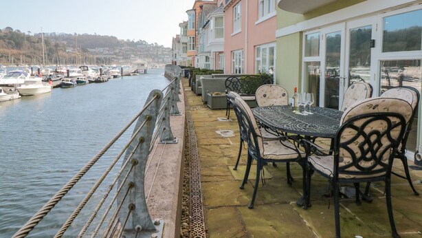 A waterfront property with a patio area featuring outdoor seating and a view of the marina. - 30 Dart Marina (Dartmouth)