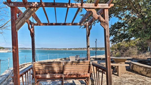 A wooden gazebo with a bench overlooking a beach and the sea. - Covered Deck & 2-story Dock: Lake Travis Home! (Leander)