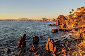 A coastal scene with rocky terrain and a beach. - Luxe Puerto Vallarta Condo, Steps From it All (Puerto Vallarta)