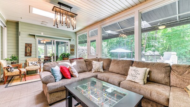 Ein gemütliches Wohnzimmer mit einem Ecksofa, einem Couchtisch mit Glasplatte und einem Essbereich mit Stühlen und Tisch.