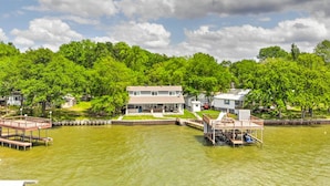 A lakeside property with a main house, dock, and a small boat. - Private Dock & Boat House: Lakefront Mabank Home (Mabank)