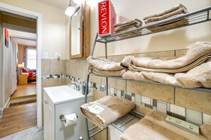 Baño con lavamanos, espejo y perchero.